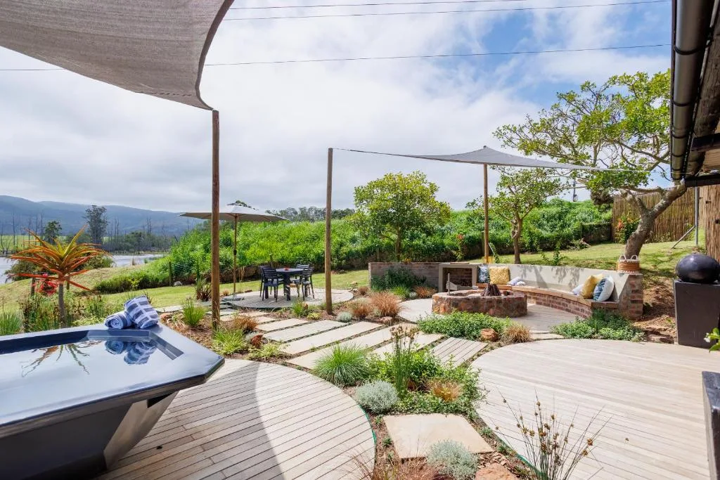 Spacious wooden deck with hot tub, shaded pergola, mountain views beyond