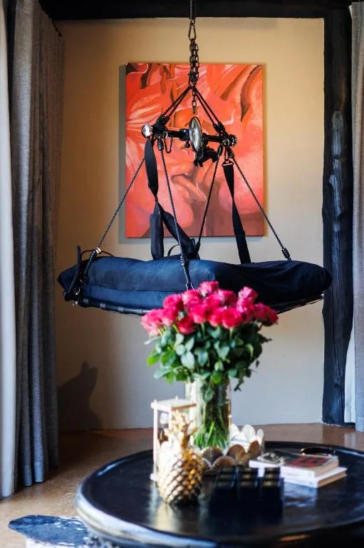 Hanging paragliding harness with vibrant art and pink flowers
