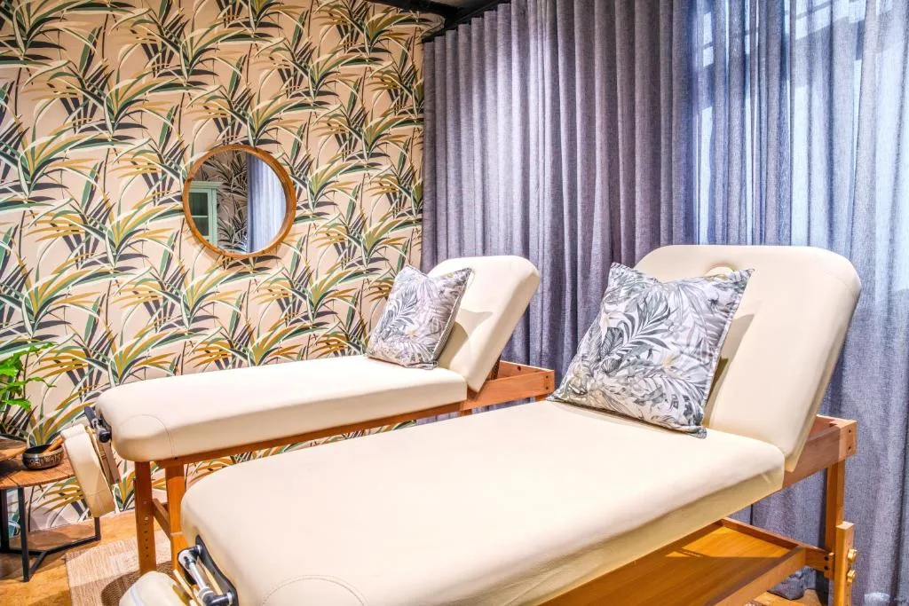 Modern lounge with botanical wallpaper, cream seating, and botanical mirror decor
