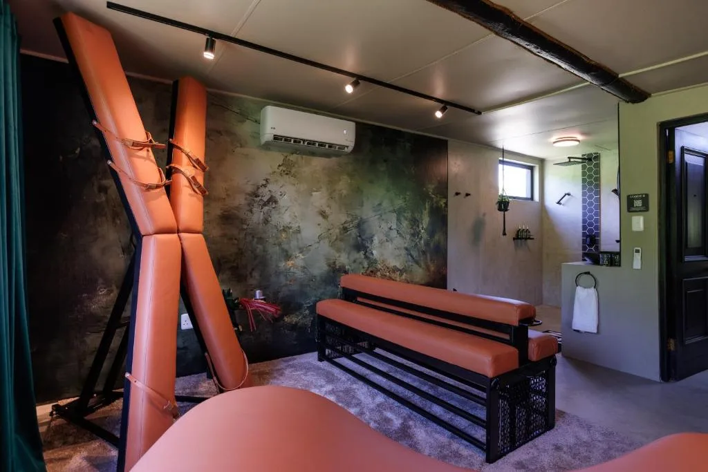 Modern lounge with orange seating, textured accent wall, and contemporary lighting fixtures