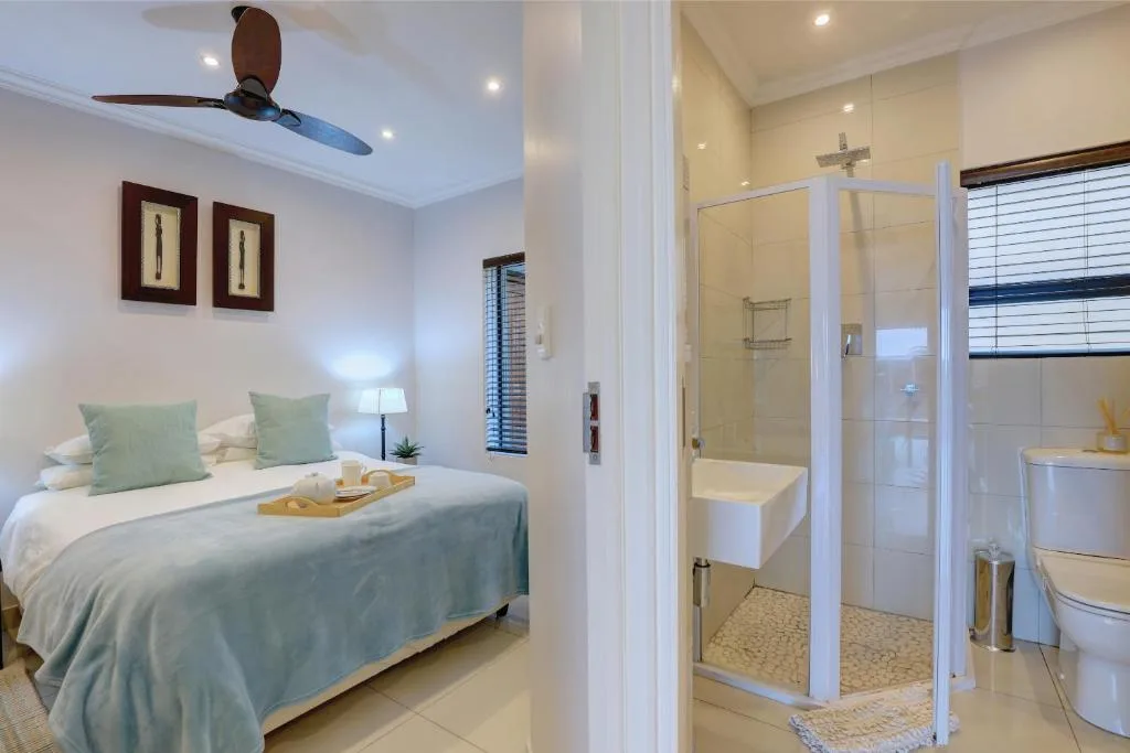 Bedroom with queen bed, ceiling fan, and en-suite bathroom visible