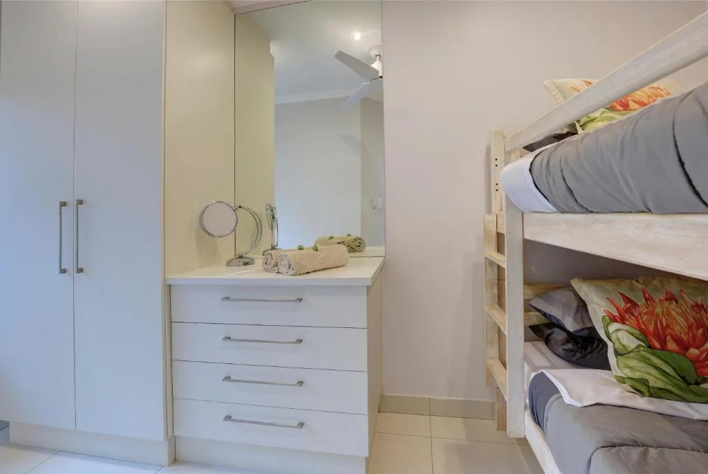 Bedroom with bunk beds, vanity mirror, storage cabinets and shelving