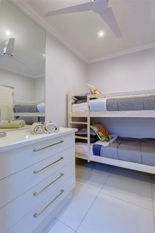 Bright bedroom with bunk beds and white storage drawers below