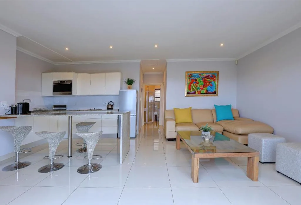 Bright lounge with beige sofa, colorful cushions, wooden coffee table