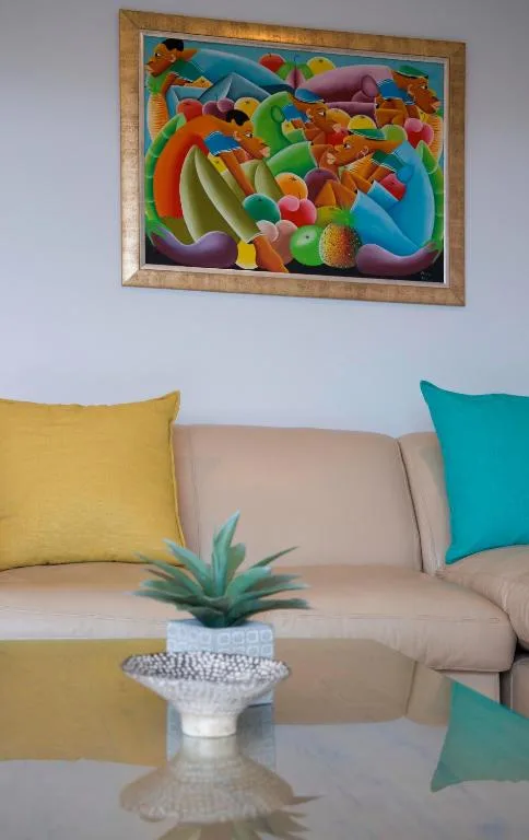 Modern lounge with beige sofa, colorful cushions, and vibrant artwork
