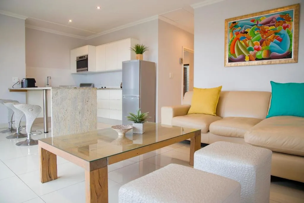 Open-plan lounge with cream sofa, colorful cushions, and modern coffee table