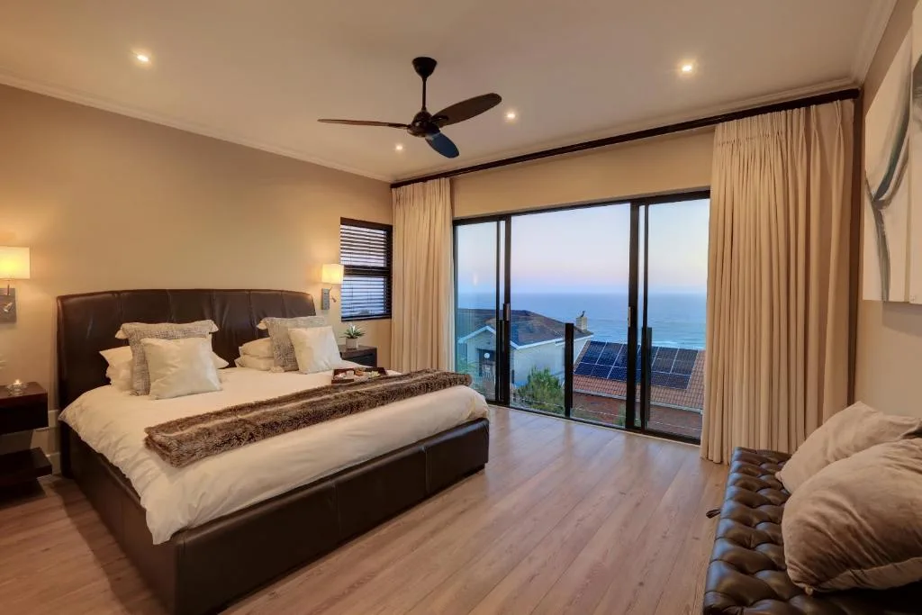 Spacious master bedroom with ocean view through sliding glass doors