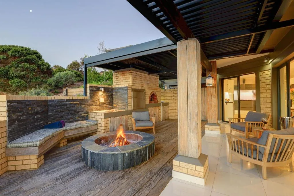 Outdoor entertainment area with fire pit, seating, and brick braai