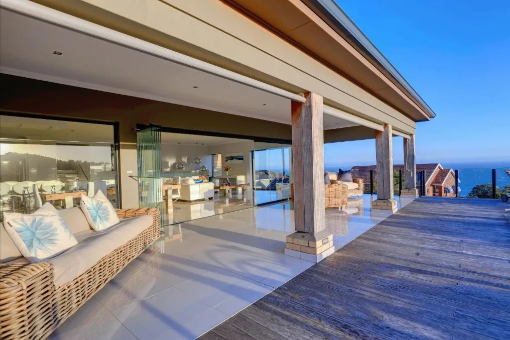 Modern wraparound deck with ocean views and wooden support columns