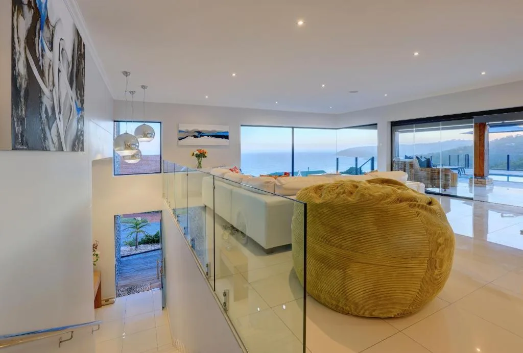 Modern lounge with sectional sofa, ocean view windows, and contemporary decor