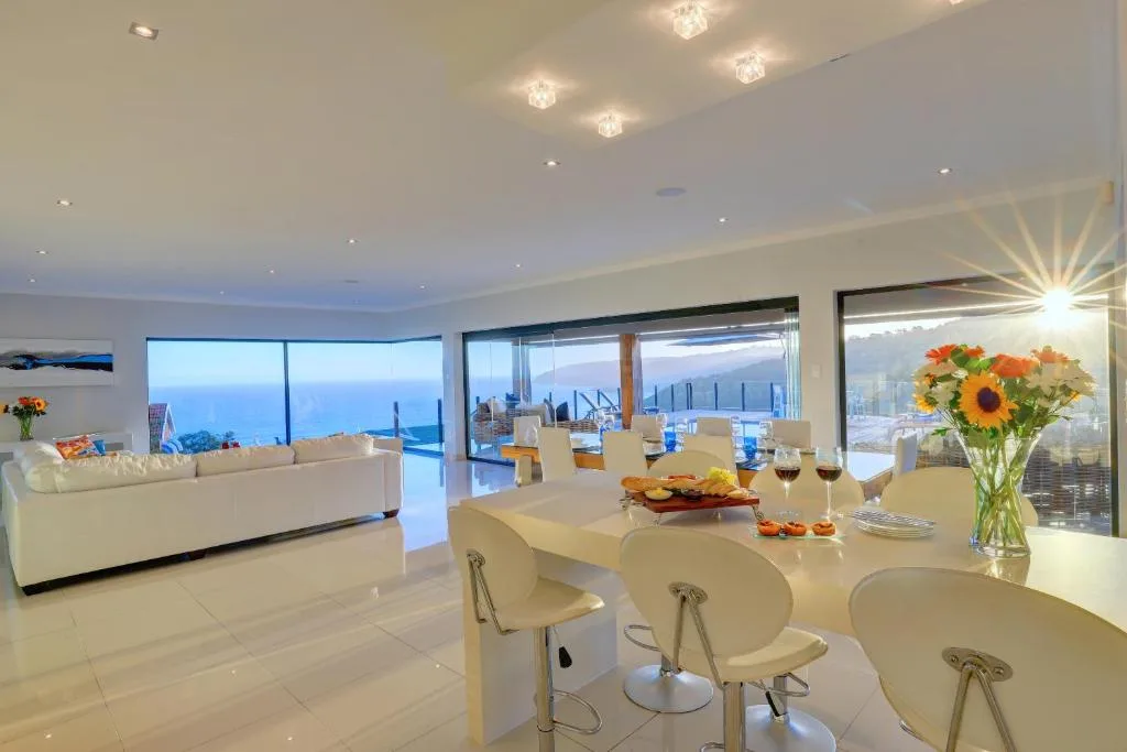 Open-plan lounge and dining area with coastal views and modern furnishings