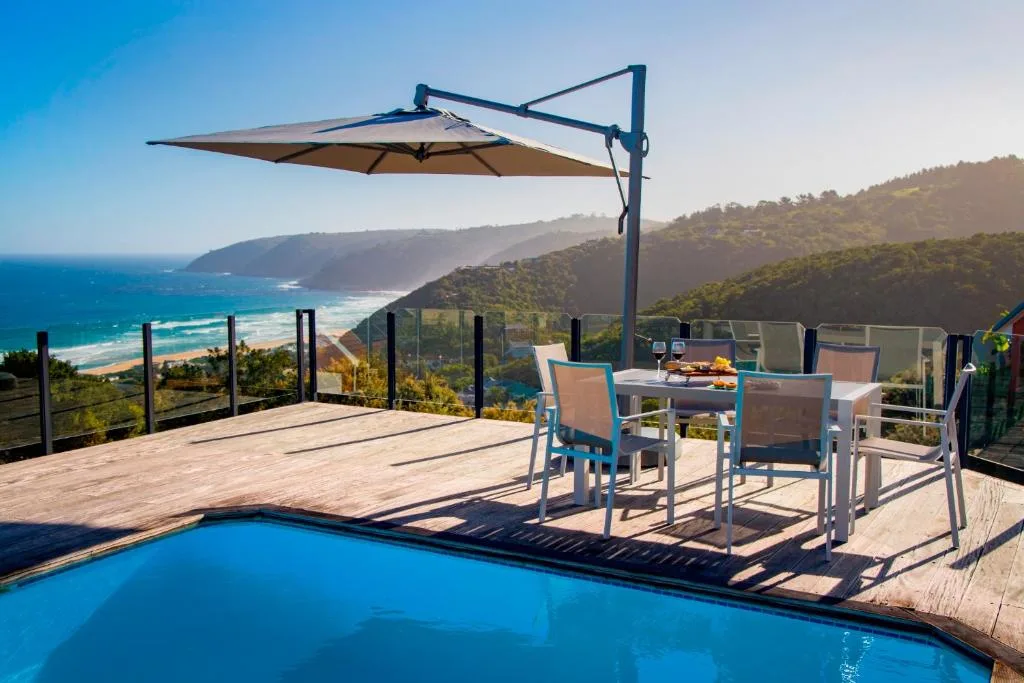 Swimming pool with ocean and mountain views on a sunny deck