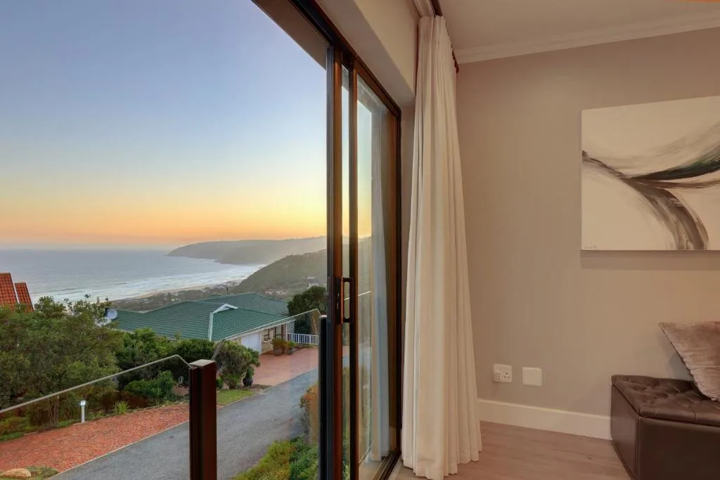 Scenic sunset view of coastal mountains and beach from indoor seating area
