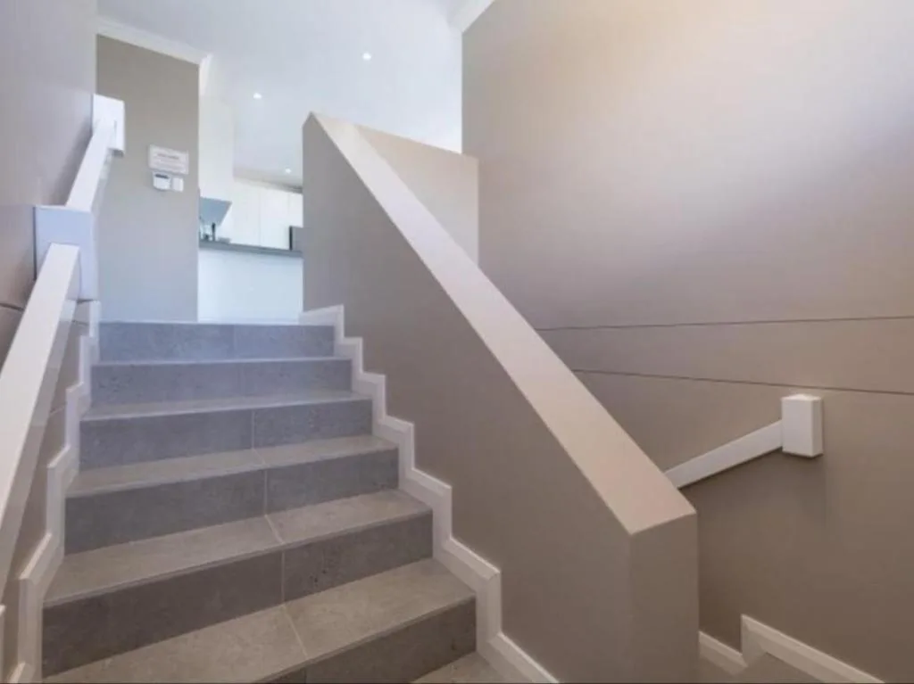Modern staircase with white railing and gray steps in contemporary interior