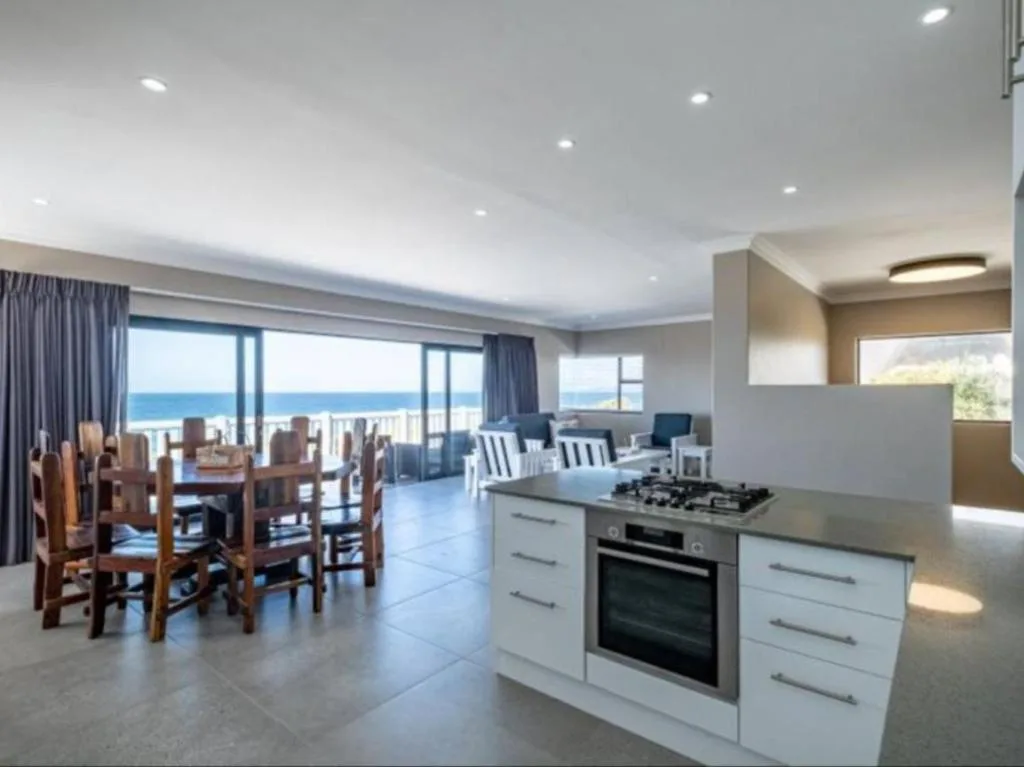 Modern kitchen with gas cooktop and oven overlooking ocean view