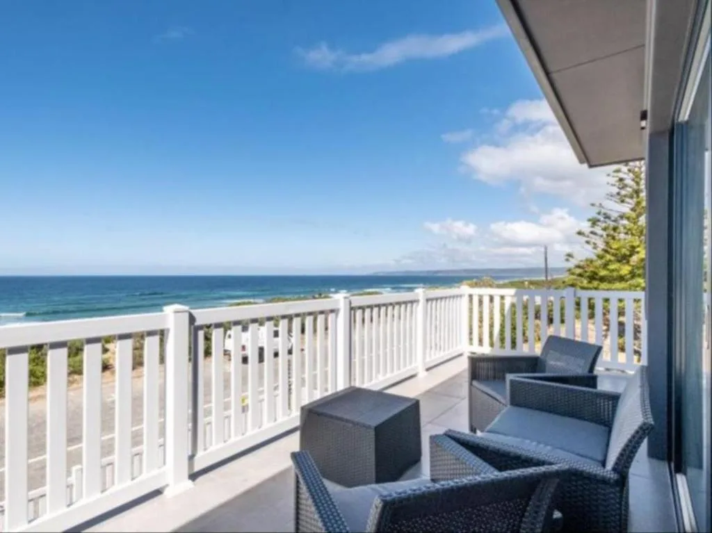 Ocean view from the deck with white railing and blue sea horizon