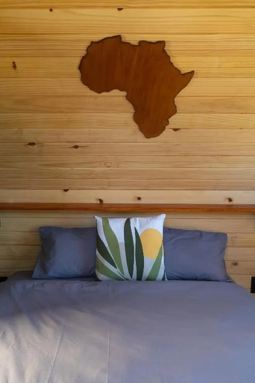 Bedroom with bed, Africa-shaped wooden wall art, decorative pillow