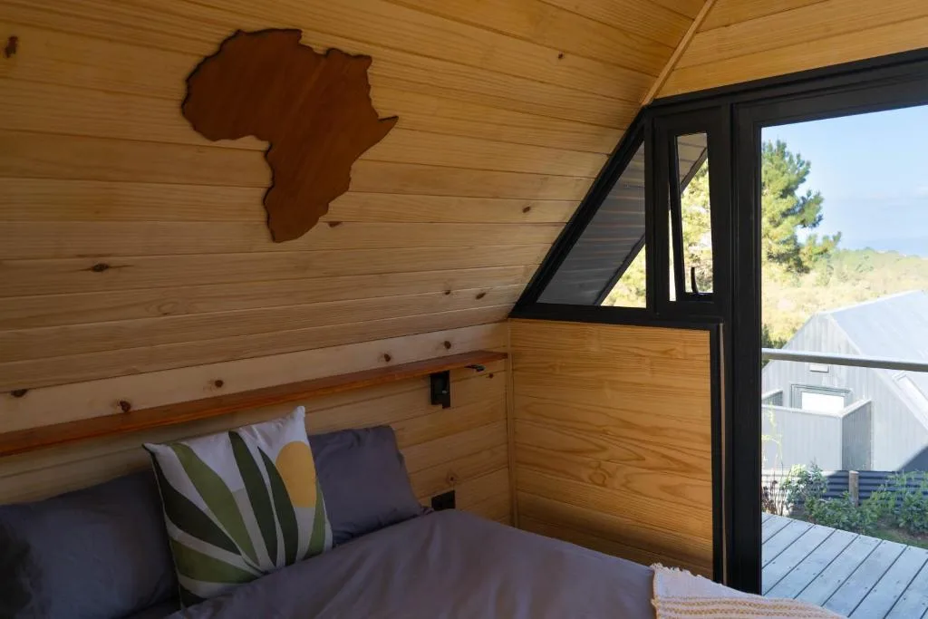 Cozy wooden bedroom with decorative Africa map and garden view
