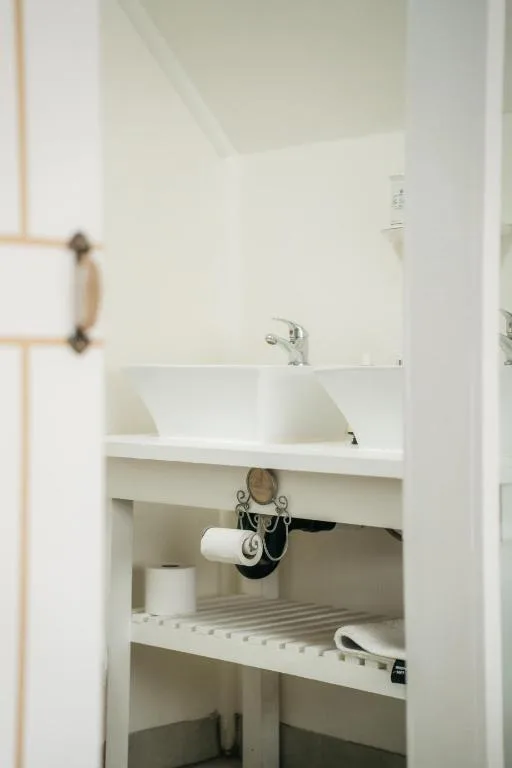 Modern white bathroom vanity with dual sinks and open shelving below