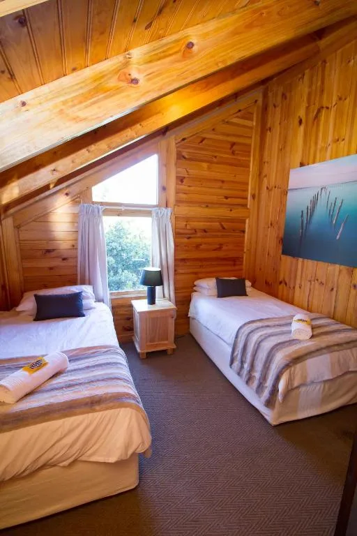Twin bedroom with wooden beams, two beds, window with countryside views