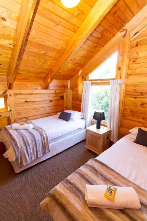 Wooden bedroom with two beds, natural light from skylight window