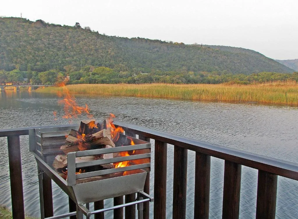 Lakeside deck with active fire pit overlooking water and mountains