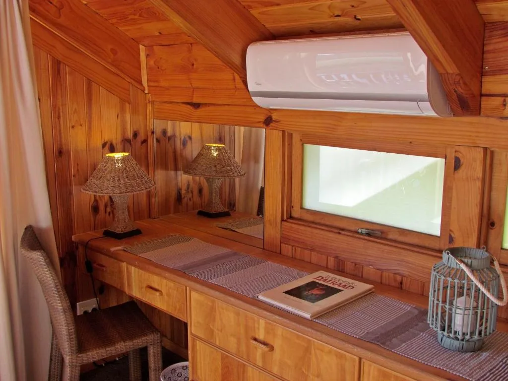 Wooden cabin interior with desk, woven lamps, air conditioning unit