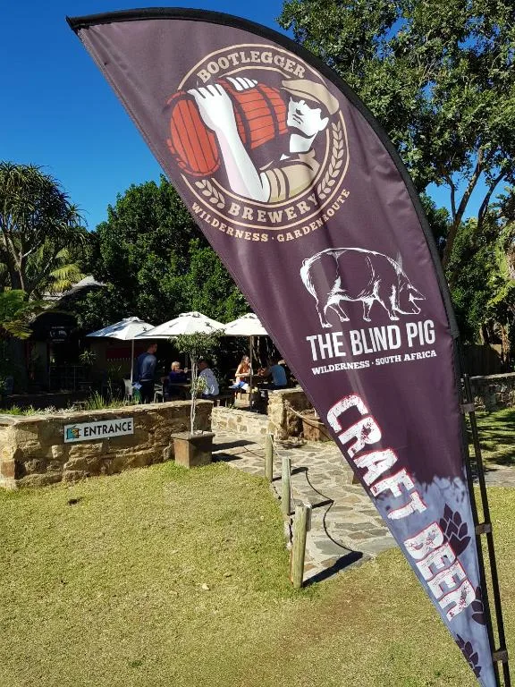 Brewery entrance banner and gardens with white umbrellas and green lawn