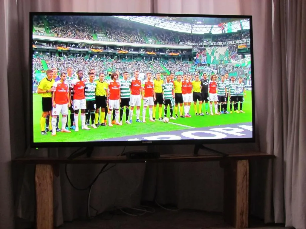 Large flat-screen TV displaying football match in comfortable lounge area