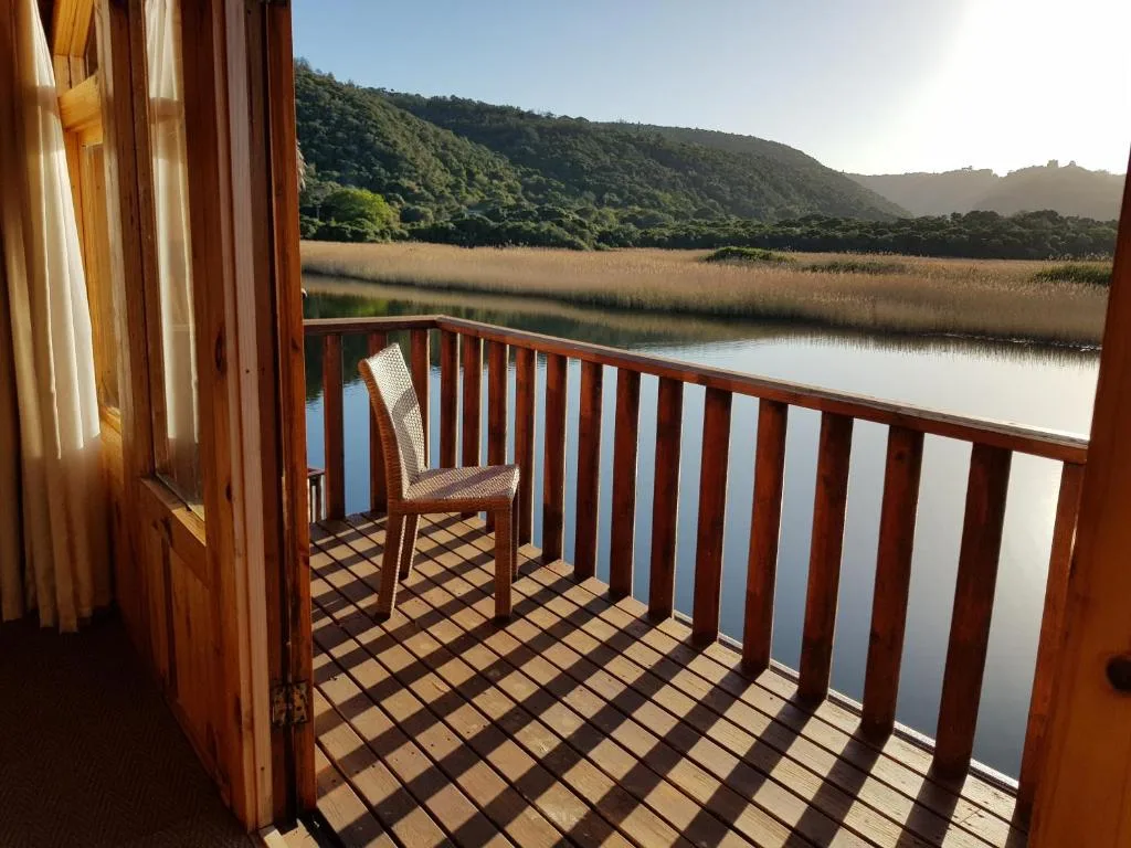 Scenic lagoon and mountain vista from wooden deck with chair