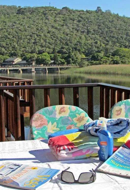 Lagoon view from wooden deck with forested hills beyond