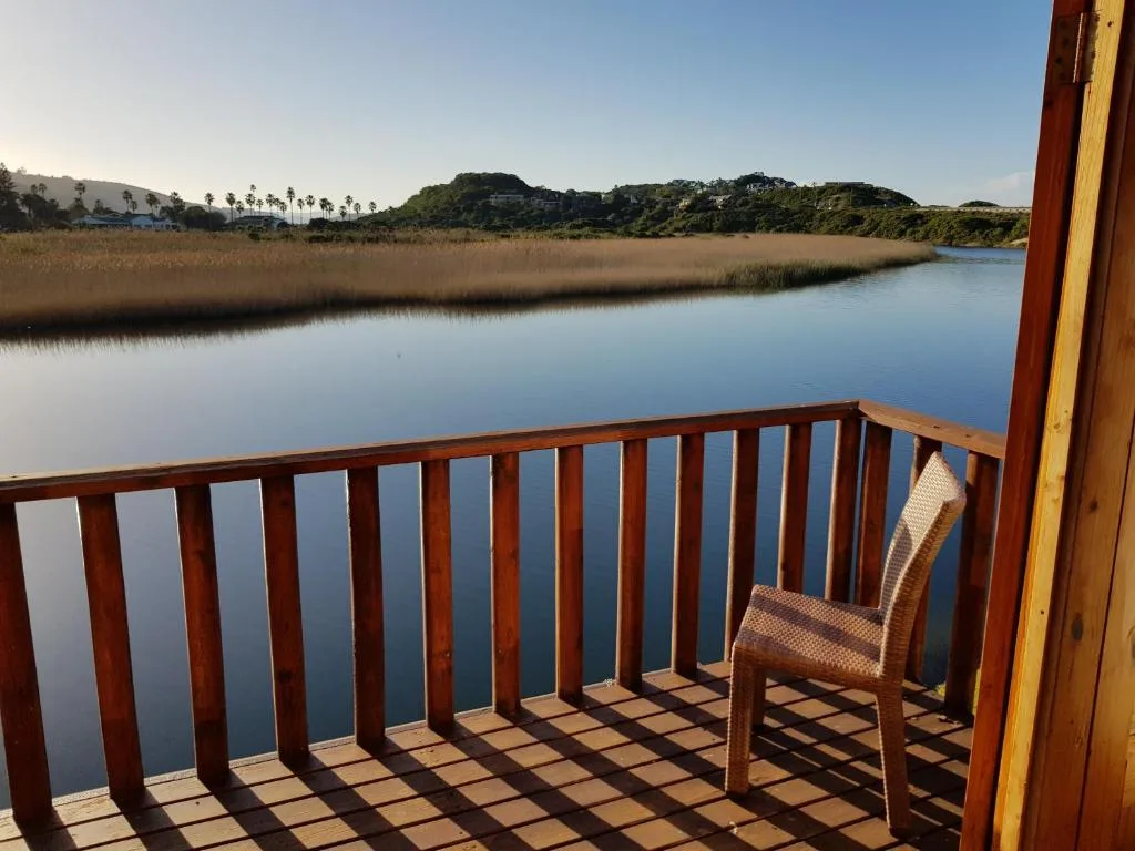 Tranquil lagoon view from wooden deck with chair overlooking wetlands