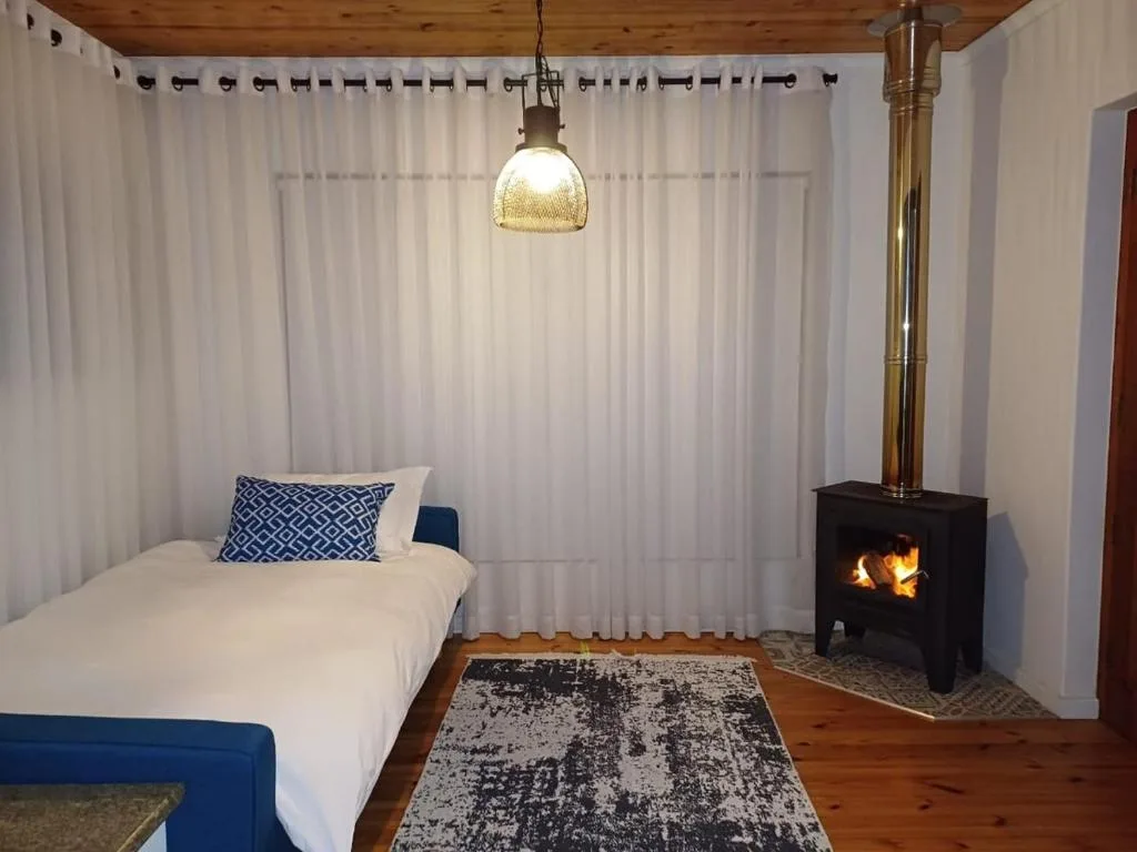 Cozy bedroom with fireplace, white curtains, and pendant lighting