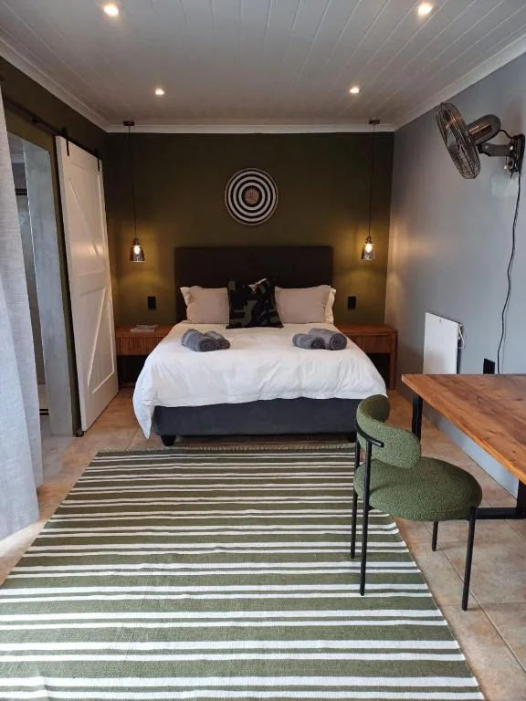 Modern bedroom with queen bed, pendant lights, and striped rug