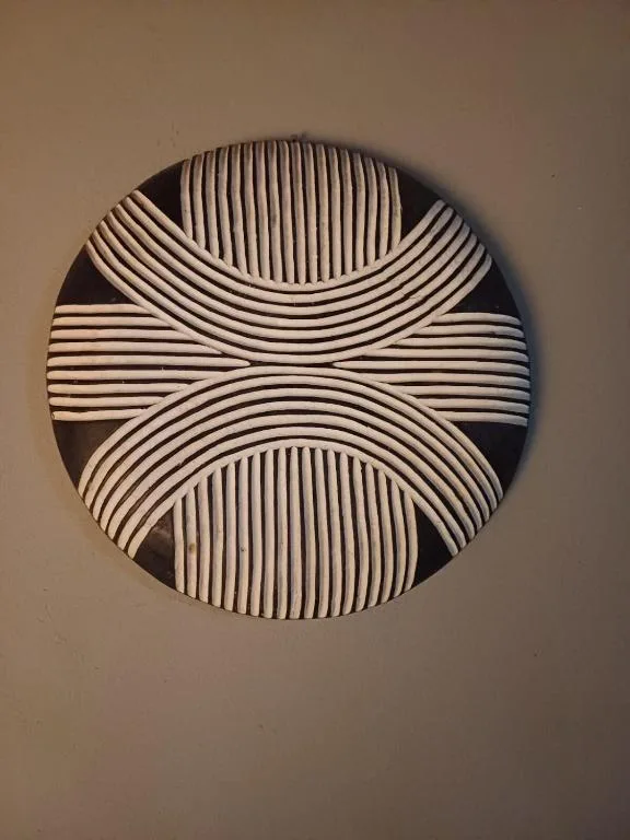 Modern geometric wall art with striped circular pattern in neutral tones
