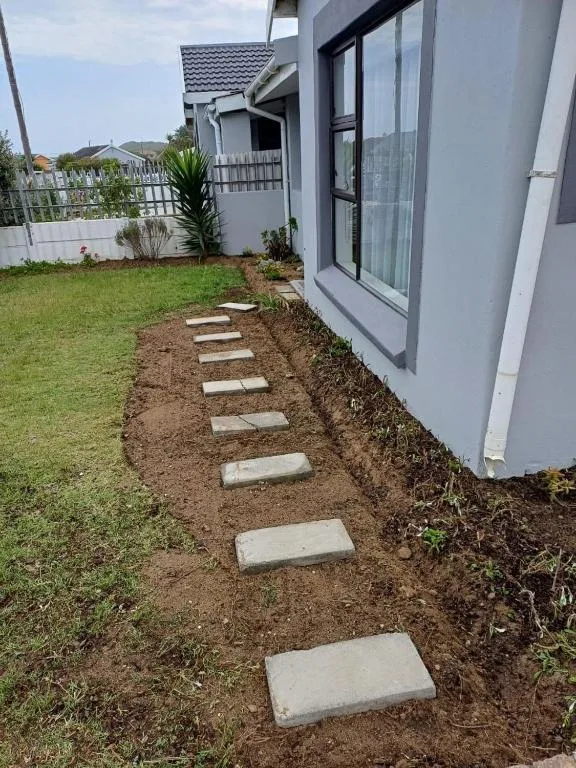 Modern white cottage with manicured garden and stepping stone pathway