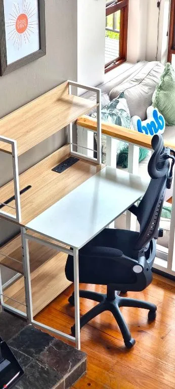 Modern workspace with desk, chair, and shelving in cabin interior