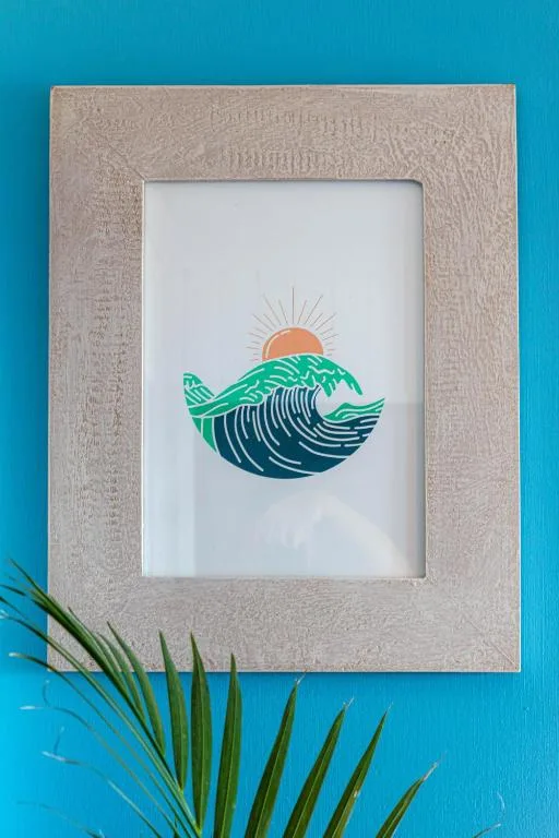 Framed coastal artwork with wave and sunset design, coastal decor detail