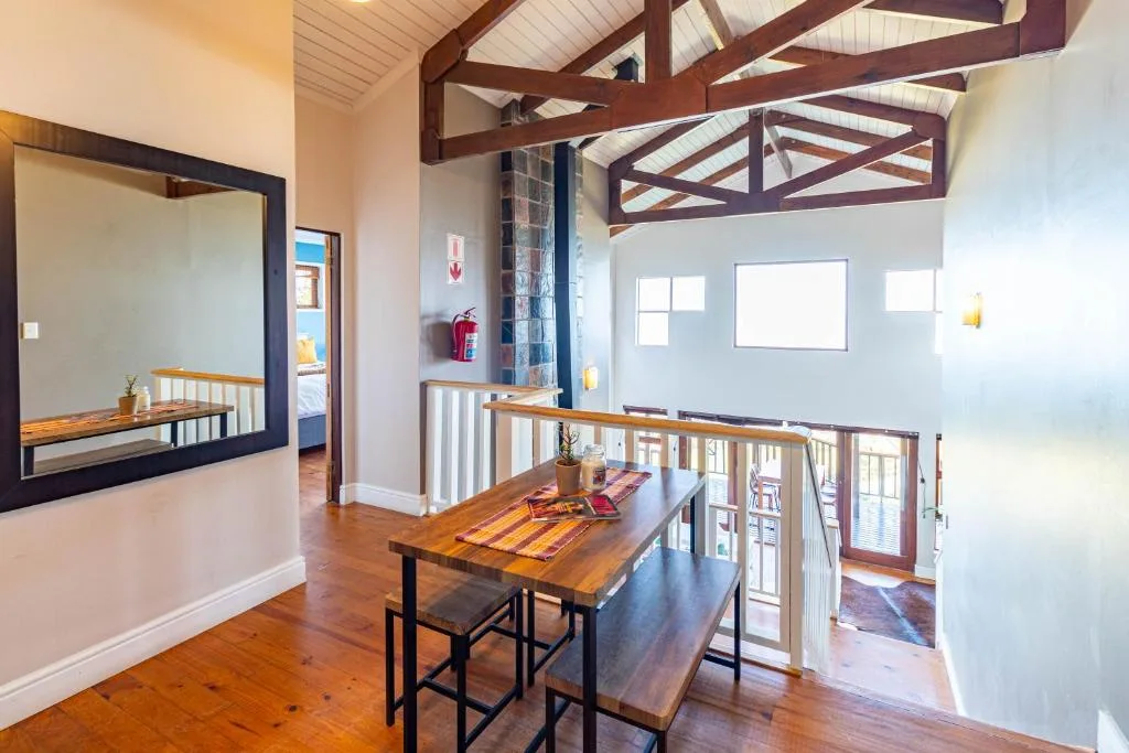 Open-plan dining area with wooden table and bar seating, vaulted ceiling