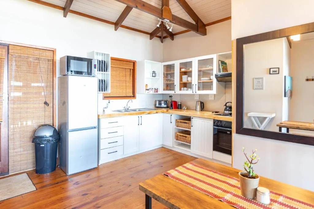 Modern kitchen with white cabinetry, wooden counters, stainless steel appliances