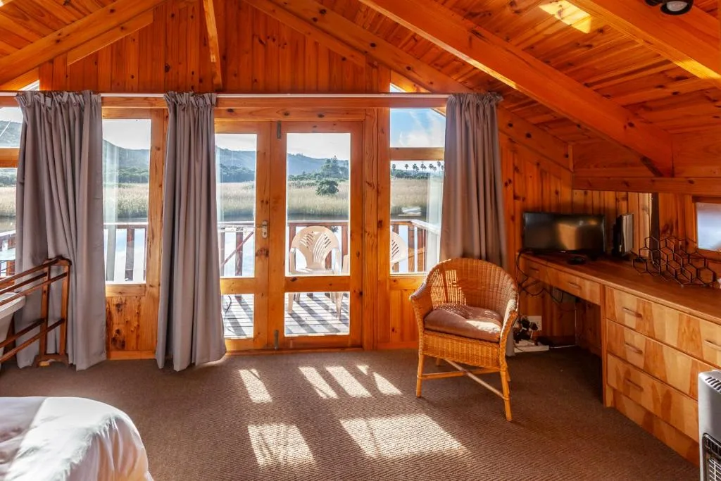 Wooden bedroom with mountain views through glass doors and deck access