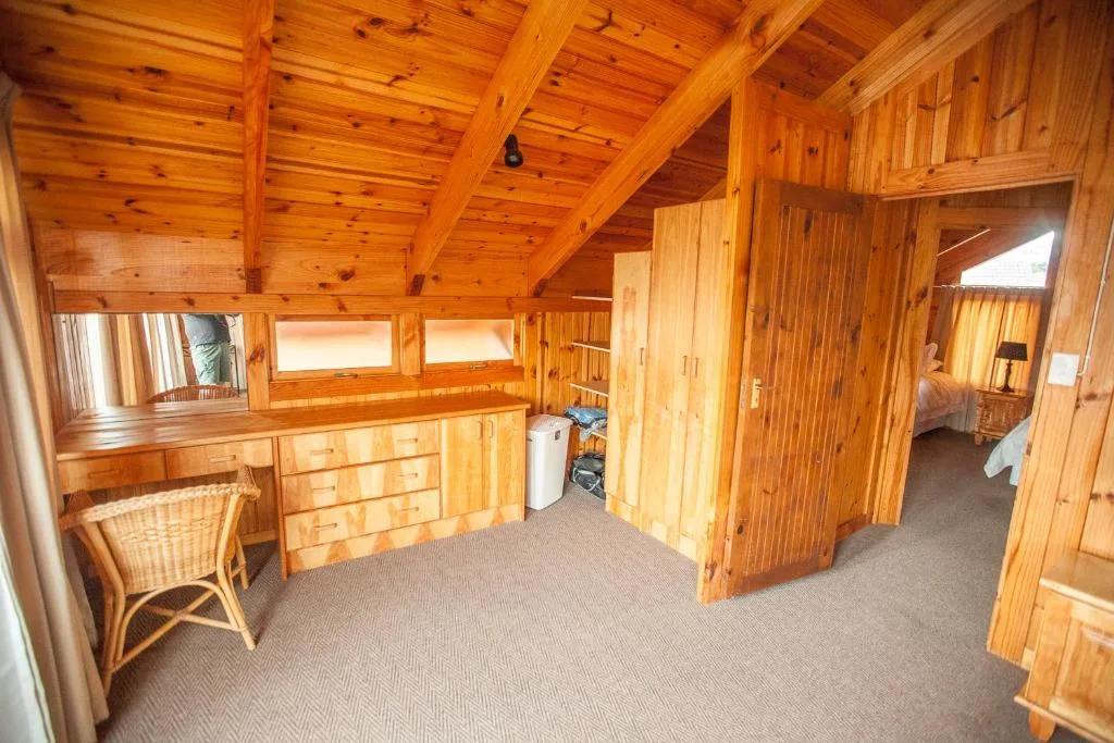 Spacious wooden chalet bedroom with vanity desk and built-in wardrobes