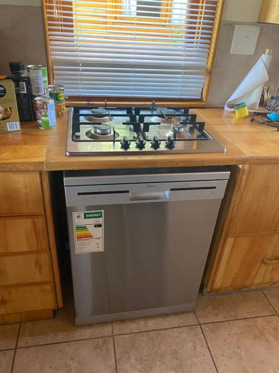 Kitchen counter with gas cooktop, dishwasher, and wooden cabinets