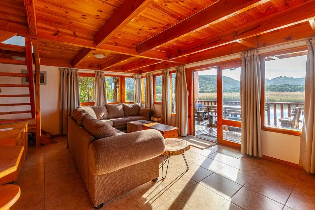 Warm wooden lounge with brown sofa, scenic mountain views through large windows