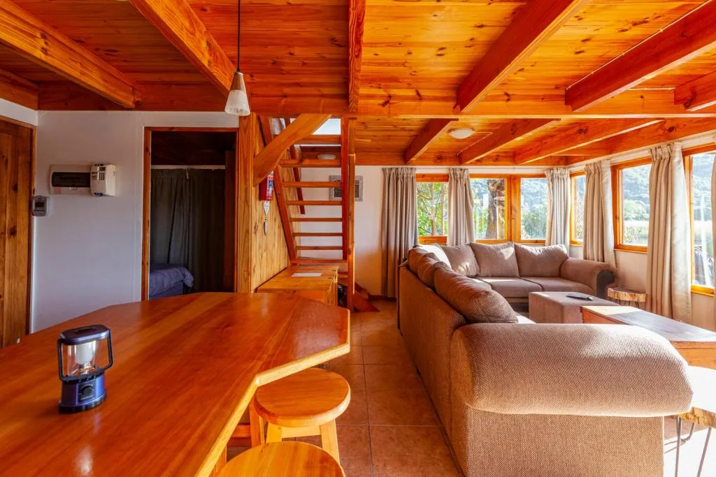 Wooden chalet interior with comfortable sofas and large scenic windows