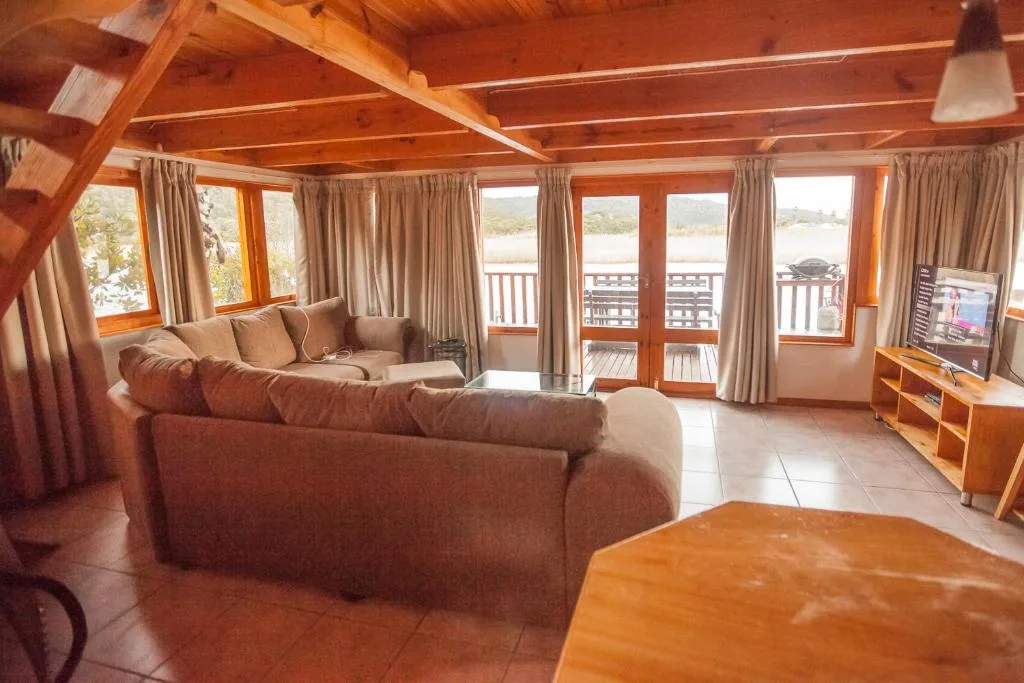 Spacious lounge with comfortable seating and panoramic water views through large windows