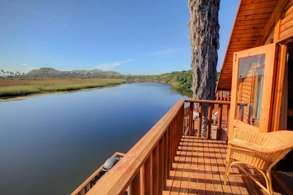 Scenic lagoon vista with mountains and native vegetation from wooden deck