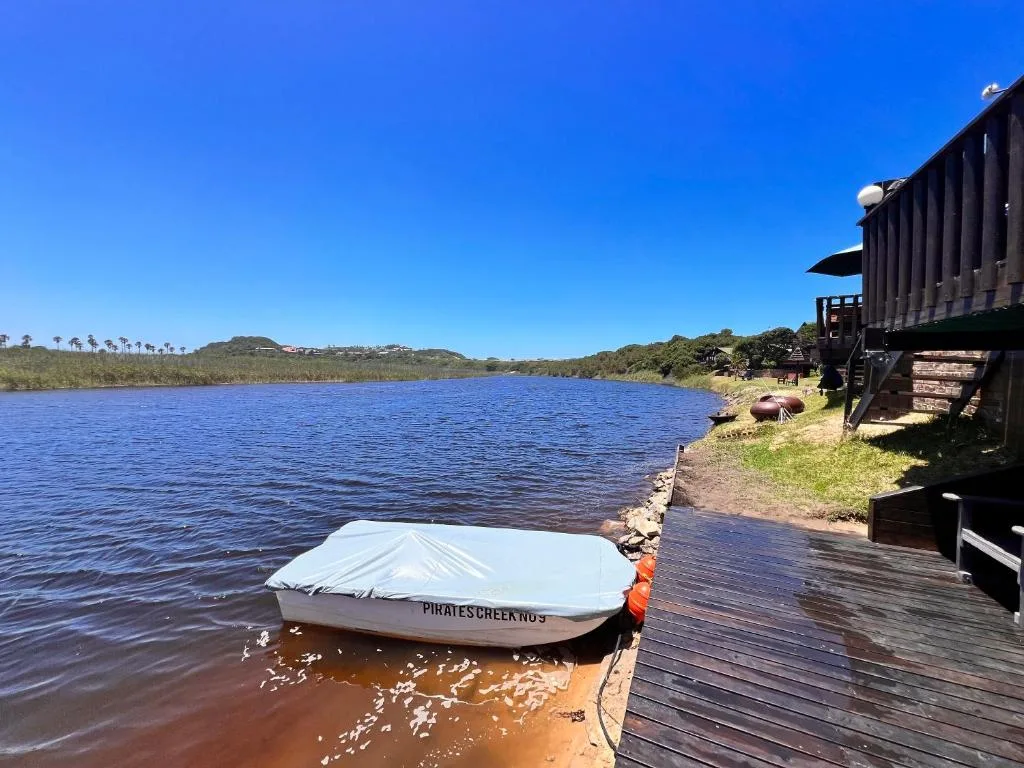 Scenic lagoon view with moored boat and lush vegetation across water