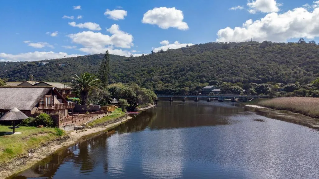Riverside property with thatched cottage overlooking calm lagoon and forested hills