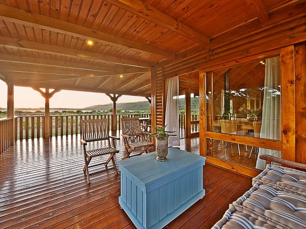 Wooden deck with covered patio, rocking chairs, and mountain views